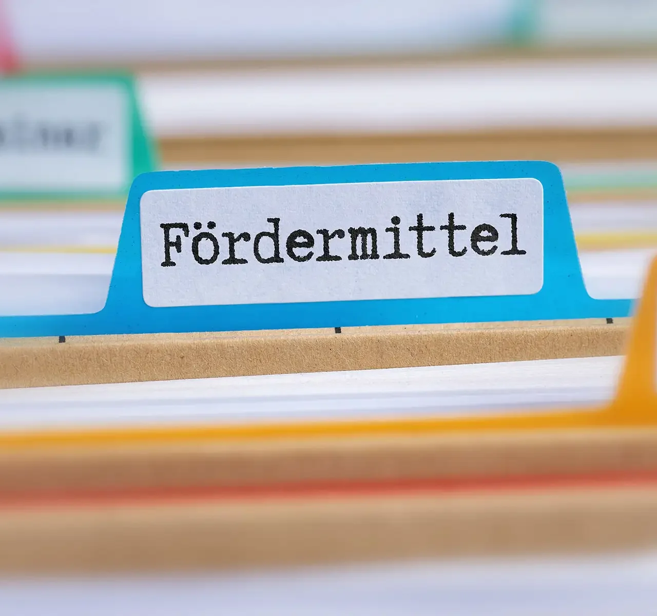 "Fördermittel" auf einem Aktenhalter