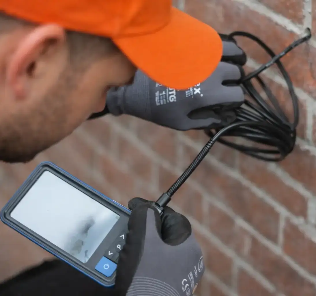 Ein Mitarbeiter bei der Prüfung eines Hohlraums zur Einblasdämmung